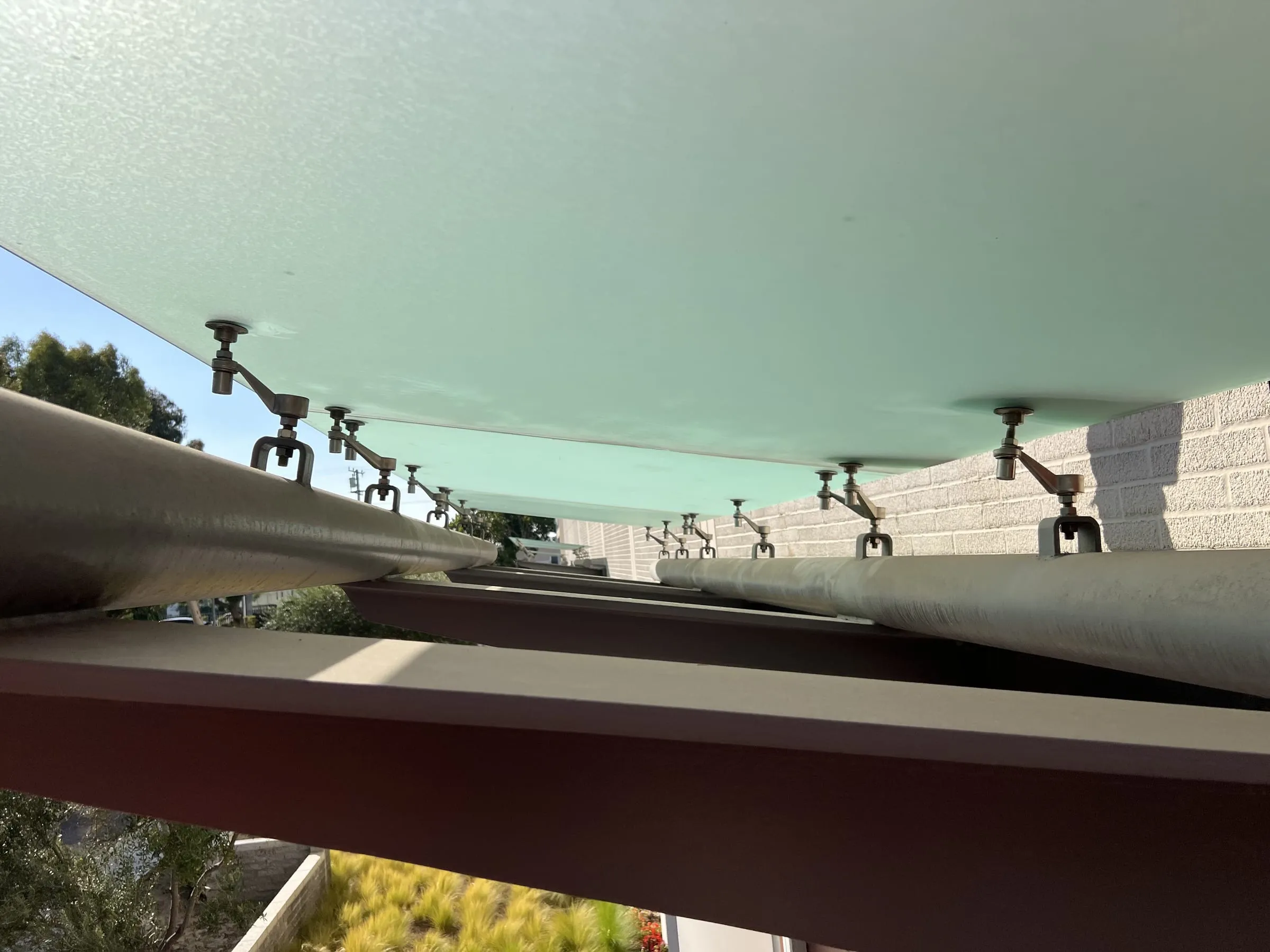 Underside of the frosted glass canopy with stainless spider fittings on round steel tubes