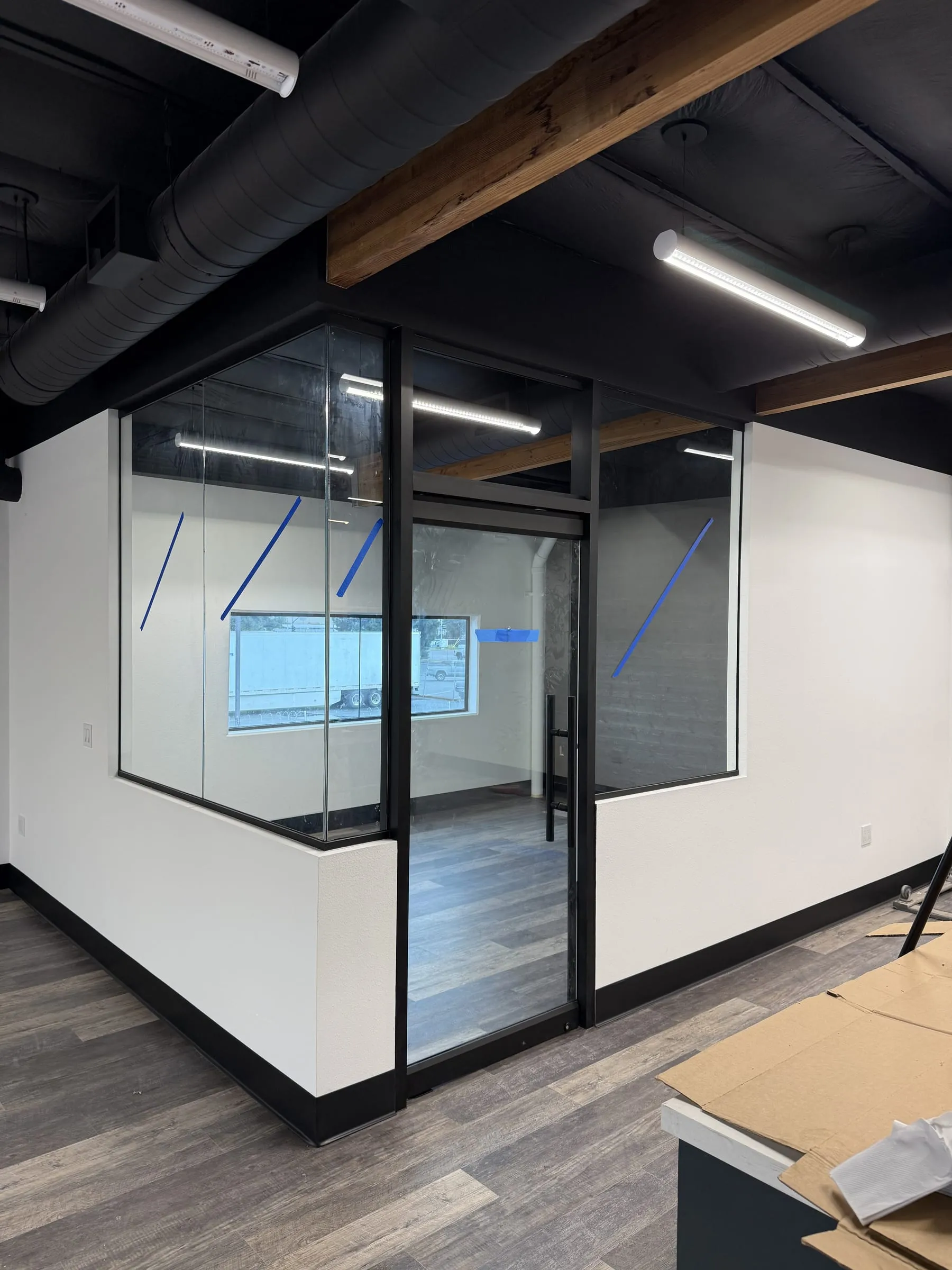 Black-framed glass partitions on half walls dividing an open office
