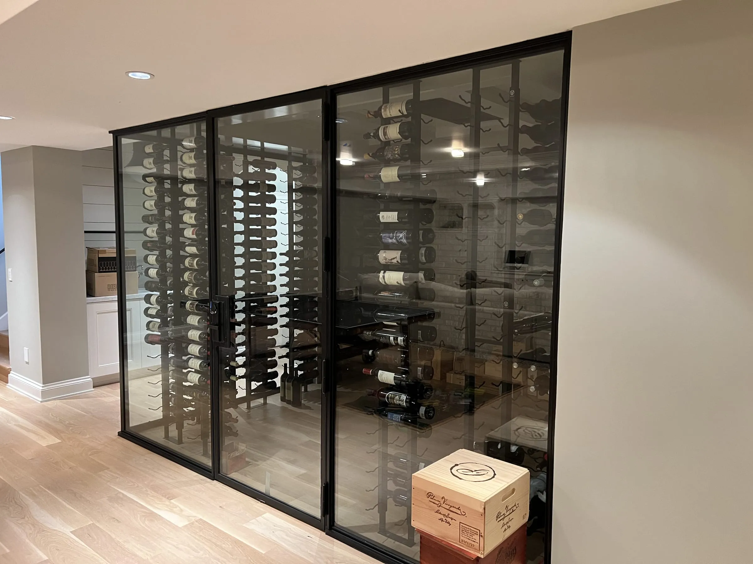 Front of the glass wine room with its glass door and wine racks